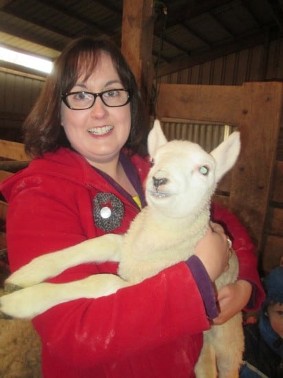 Sarah holding baby lamb at the farm.